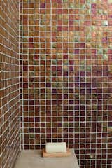 The bathrooms feature Oceanside Glasstile recycled glass tiles from Mission Tile West, in palettes inspired by the home’s coastal setting. The ground-floor bathroom is tiled in brown like the earth, the guest bathroom in seafoam green, and the master bathroom in blue like the sky.