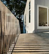 An aluminum water-jet cut fence divides separates the house from its neighbors.