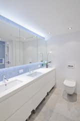 In addition to a playroom, the children share a bathroom. “In a kids’ bathroom, it’s nice to have a little bit more fun,” Miller says. “The penny tiles are really nice because they are really inexpensive and have a nice blue delicateness to them.” A neutral palette of whites and grays is used throughout the rest of the space to make the blue penny tiles stand out. Footstools are nestled underneath the cabinets so the kids can access the sink easily.