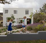 During construction, workers enlivened the white, painted exterior of the 3,143-square-foot home by insetting some bricks with a rubber mallet, creating a muted pattern of shadows that dance across the façade.