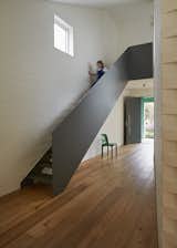 At the top of the steel staircase, a window-lined hallway wraps around the inner courtyard as it leads to the playroom. The upper level also includes the children’s bedrooms and bathroom.