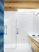 The bathroom is covered in Heath tile and indigo Eskayel wallpaper. The Ghost chair is by Philippe Starck.