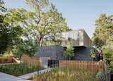 Working with a sumptuous material palette, Ehrlich Yanai Rhee Chaney Architects designed a sprawling new residence in Palo Alto for Mark and Laura Pine. The teak wood and handmade Danish bricks that define the exterior are used inside as well; distressed stainless steel panels by Chris French Metal sheathe one side of the upper volume. Blasen Landscape Architecture chose Peruvian feather grass to flank the entrance walkway.