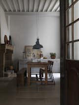 Even limestone townhouses built in the 1200s look good with a modern update. Homeowners Lone and Chris bought their home in Uzès, France, and worked without the help of an architect to give it present-day appeal. When incorporating newer dining room designs into a medieval house, you must choose decor that suits the home. Lone and Chris brought in vintage chairs, an oak dining table, 1960s pendant lamps, and artwork, setting it up in front of the original stone fireplace, creating an inviting place to gather.