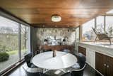 Designed in 1954 by architect Peter Womersley, this midcentury-modern home in West Yorkshire, Britain, features a sunken dining room with elements of wood and stone, complementing the natural view through the oversized window. Carlick Furniture manufactured the table and it’s surrounded by limited-edition chairs from Fritz Hansen.