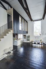 The charred reclaimed oak on the ceiling continues onto the exterior of a loft space overlooking the dining area. Mod 265 wall lamps by Paolo Rizzatto for Flos illuminate a vintage trestle table that belonged to Claire’s family. The original pine floor boards were stained a chocolate brown.