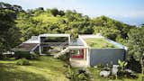 A series of open and closed volumes, the house incorporates a range of materials, including local mahogany, standing-seam metal, shingled glass, and concrete. A green roof tops one end.