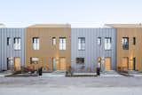 The homes with a north-south orientation feature silver facades. Wooden slats are affixed to every other residence for visual variation.