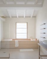 VOLA towel-warming rails climb the wall next to a custom-designed soaking tub crafted in Japan out of hinoki wood, or Japanese cypress.
