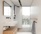 Even the bathroom grants views. Sleek wood elements complement the white-and-black fixtures and details.  