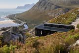 In the midst of the pandemic, a family leverages industry connections and modular construction to quickly rebuild a cliffside getaway on a fire-ravaged site in the Kogelberg Biosphere Reserve.