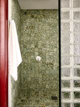 "By keeping the main color block in the showers, we tried to contain the chaos to a small and palatable space within the bathroom," Cooper says. "It's fun when you're in there, but you're not overwhelmed when using the bathroom for other purposes."