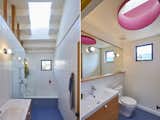 Left: The designers placed a sink vanity and a bathing area in one of the baths, where a rectangular skylight floods the space with sunshine. Right: The second bath, where there's a sink vanity and a toilet, features an oval-shaped skylight accented with a brilliant shade of hot pink.