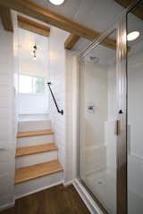 The bathroom features a shower with a glass door and a partial glass wall.