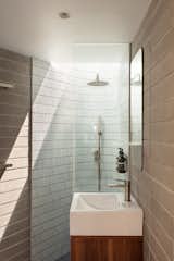 The small bathroom on the first level features concrete block walls and ceramic mosaic tile for the shower walls; a skylight in the shower supplies an indoor-outdoor experience.