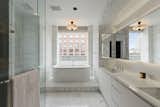 The master bath features Statuary marble, radiant heat floors, a Kaldewei Vaio Duo oval freestanding tub, a frameless glass-enclosed shower, Lefroy Brooks fixtures and a Valcucine vanity.