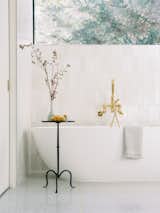 A deep soaking tub and a large picture window add to the bathroom’s luxurious vibe.