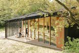 The Holiday Home's bright and airy sculptural design features a black exterior paired against a warm and welcoming natural wood interior.