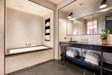 The master bathroom features a custom-designed vanity with bronze legs, a walk-in steam shower, multiple storage cabinets, and oil-rubbed bronze fixtures by Lefroy Brooks.

