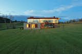 The home's two volumes are distinct not only in their orientation, but also in their materiality. The lower level is wrapped in stone, while the upper level is composed of glass.