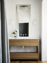 In another bathroom, white penny rounds cover the walls. The original window and casework give off historic gravitas and provide a thoughtful counterpoint to the modern tile treatment.