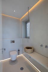 In the bathroom, the clay plaster walls meld with high-gloss tile floors. A Bruma sink faucet descends dramatically from the ceiling.