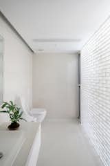 The color palette was reversed in the bathroom—glass brick lines the wall in a nod to the other materials in the project.