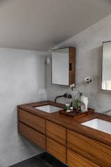 The new custom teak vanity and tub surround were designed by Jocie and fabricated by O’Brien Wood & Iron. At the vanity, Kohler sinks are joined with California faucets and medicine cabinets by Urban Outfitters. The vase is from Summer School.