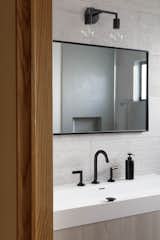 Large-format wall tiles create organic texture in a neutral color, consistent with the the rest of the house. 
