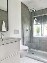 The marble herringbone floor tile is from Lowe’s, and the walls are covered in waterproof concrete plaster, a finish that took up less room than tile would have. “The walls were really un-level and it's not a particularly big bathroom, so I didn't want to reduce the size of it,” says Segulja.