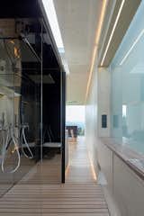 Seamless transitions occur between spaces. A frosted glass window allows daylight to fall into the bath space, while also providing privacy.