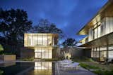 The transparent second-floor volumes appear like lanterns set atop the limestone plinths. 