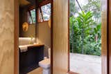 The minimal material palette extends into interior living spaces—including the bathrooms.