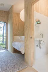 A small yet full-sized bath houses a tub, compost toilet and sink.