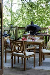 A MORSØ wood-fired pizza oven sits beside a Marseille four-seater dining set.