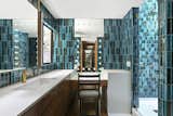 The master bath is covered in vibrantly colored tile.