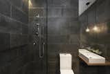 The bathroom is fitted out with Tudo & Co pendant lights, a Caroma Urbane toilet, Studio Bagno Manhattan basins, and Phoenix Vivid tapware.