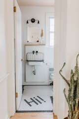 The updated hallway bathroom has a lot more personality with a Rejuvenation sink, a Wayfair faucet, and playful floor tile from a local tile shop. For a pop of color, the ceiling was painted Pink Ground by Farrow & Ball.
