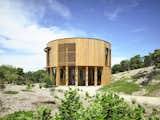 To take in views of Victoria’s coastline from all directions, Austin Maynard Architects crafted a bach-inspired beach house using a circular, corridor-free design and full-height glazing. Exposed trusses and a simple material palette keep focus on the outdoors, while rooftop solar panels and a rainwater harvesting system help the dwelling reduce site impact. 