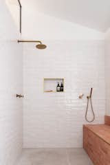 The floors are Surface Gallery terrazzo gray tiles. A tiled bench was added in consideration of the clients who plan to retire in the home.