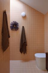 The upstairs ensuite bathroom is covered in orange tiles. All the tiles used in the bathrooms, kitchen, and service area are by Classic Ceramics.