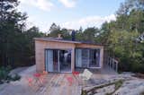 The uneven edges of the elevated pine deck trace around the exposed rocks.