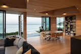 Large sliding doors, corner windows, and covered decks blur the boundary between indoors and out.