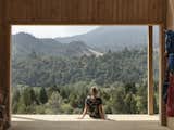 The Outdoor Room frames west-facing views of the Kaimai Range. “With timber-battened clear roofing above, it perfectly frames the forest views beyond, creating moments of uninterrupted connection and stillness with nature,” note the architects.