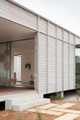 Concrete off-form steps by FABPREFAB step down into the courtyard.