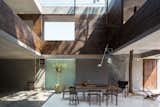 A water-basin skylight illuminates the core of the house—from the roof to the dining area at the heart of the ground-floor living space.
