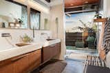 The master bath of Highlands Ranch features twin Duravit cabinets with concrete sinks, all lit from above by an automated skylight. SGS' design provides passive cooling when coupled with the garden-level windows. The ocean view shower provides a seamless indoor/outdoor bathing experience.
