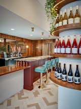 The bar, topped in Amazonite Quartzite and complemented by mirrors, wood, and seating reminiscent of a diner, is a highlight of the space.