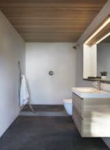 The master bathroom uses plastered shower walls and a large window to maintain a simple, direct rapport with the outdoors.