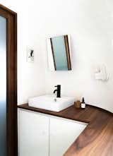 The minimalist bathroom features another walnut countertop. The Airstream’s curves and lack of straight walls presented a challenge for August, who built all of his own cabinetry.